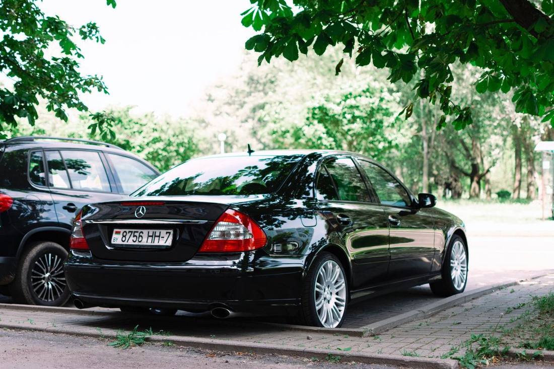 A director stepping from a black sedan at a private club's entrance
