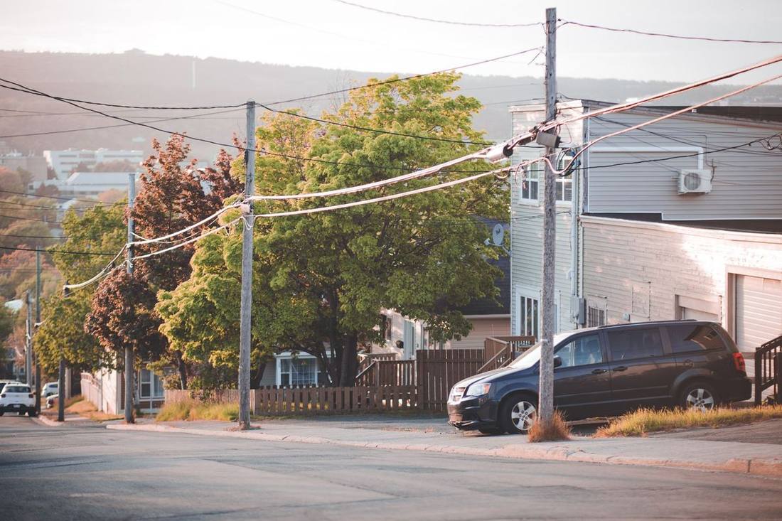 A black SUV on a Kingsway crescent lined with mature trees