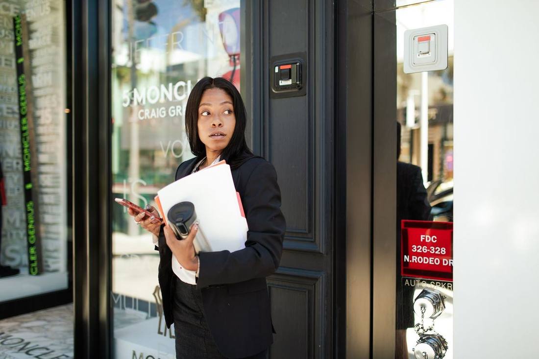 A chauffeur holding a door on University Avenue outside a hotel forecourt
