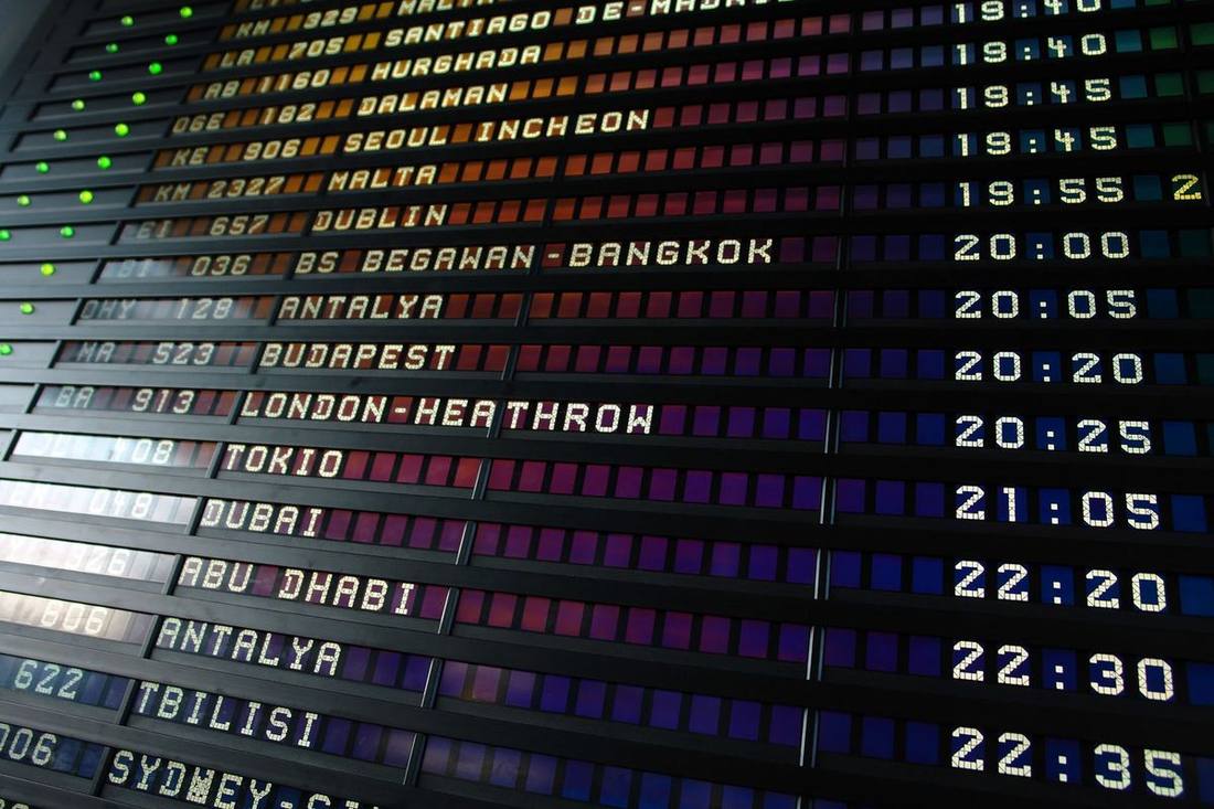 A group gathering at a name board in an arrivals hall