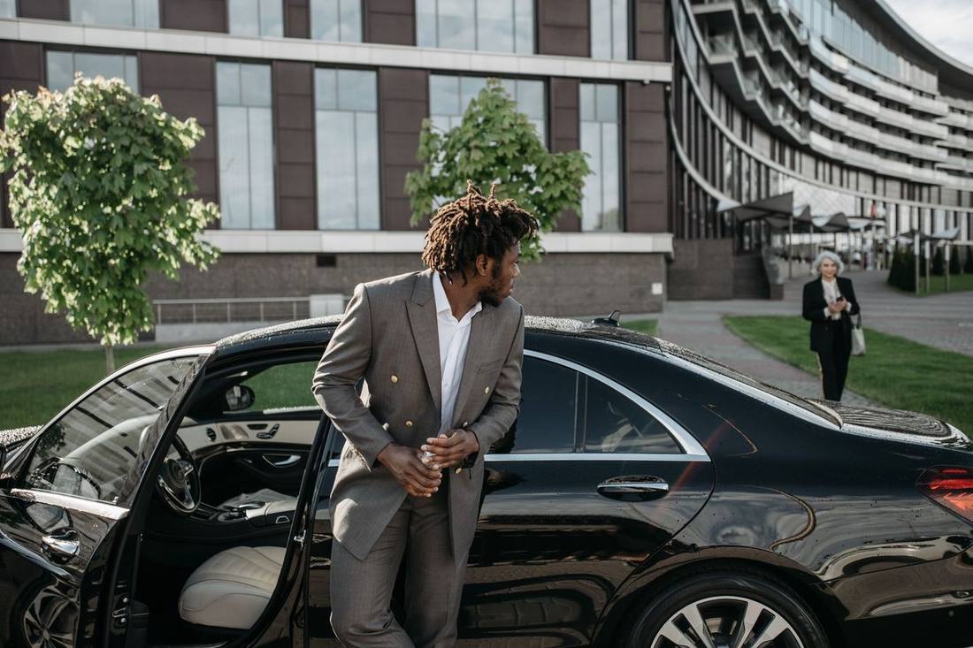 A black sedan arriving at a King West office lay-by