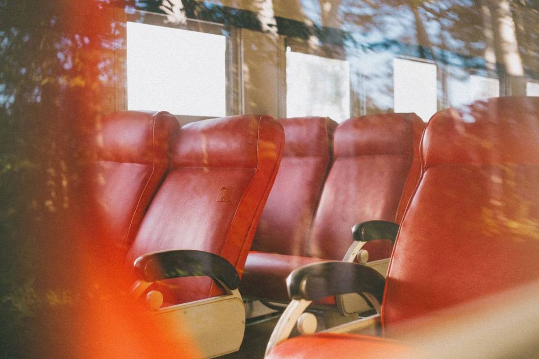 The interior of a limo bus with perimeter leather seating, a lit bar and LED ceiling lights