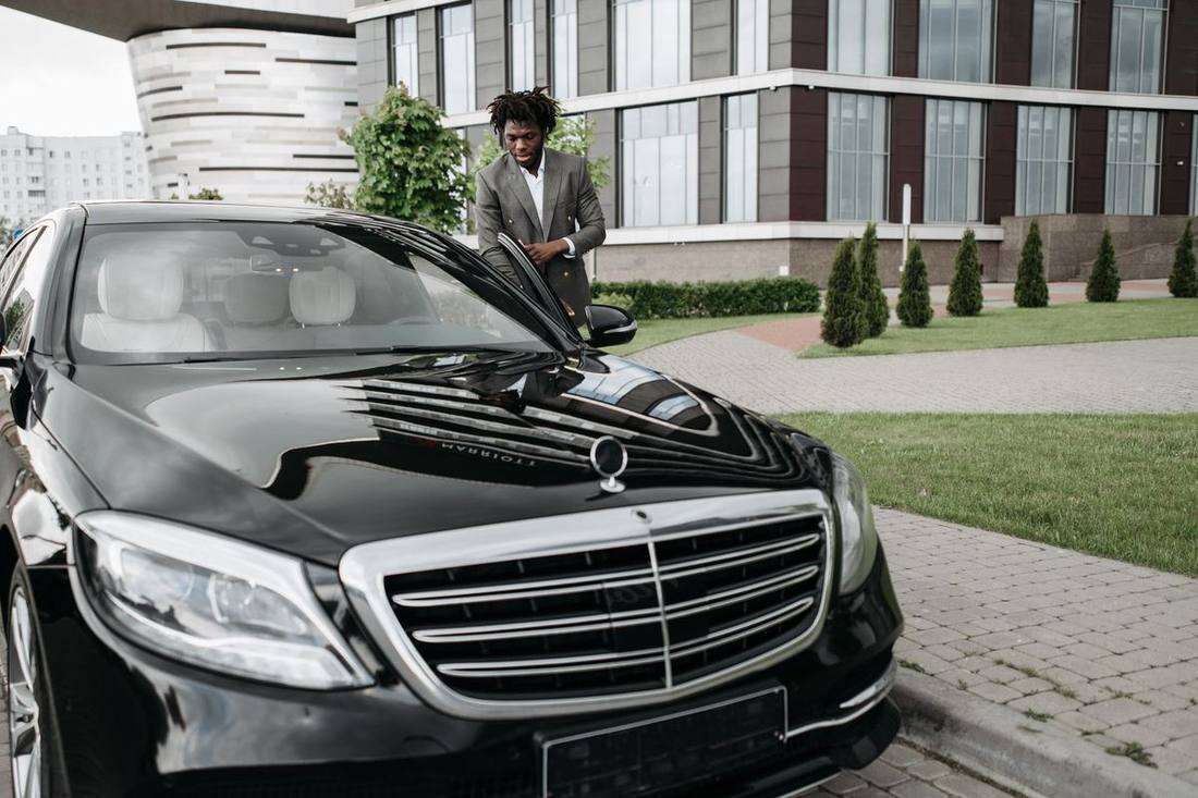 A Sprinter and black sedans outside a Financial District tower during conference week