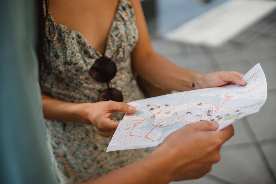A touring couple and their chauffeur consulting a map beside a black SUV at a Georgian Bay lookout