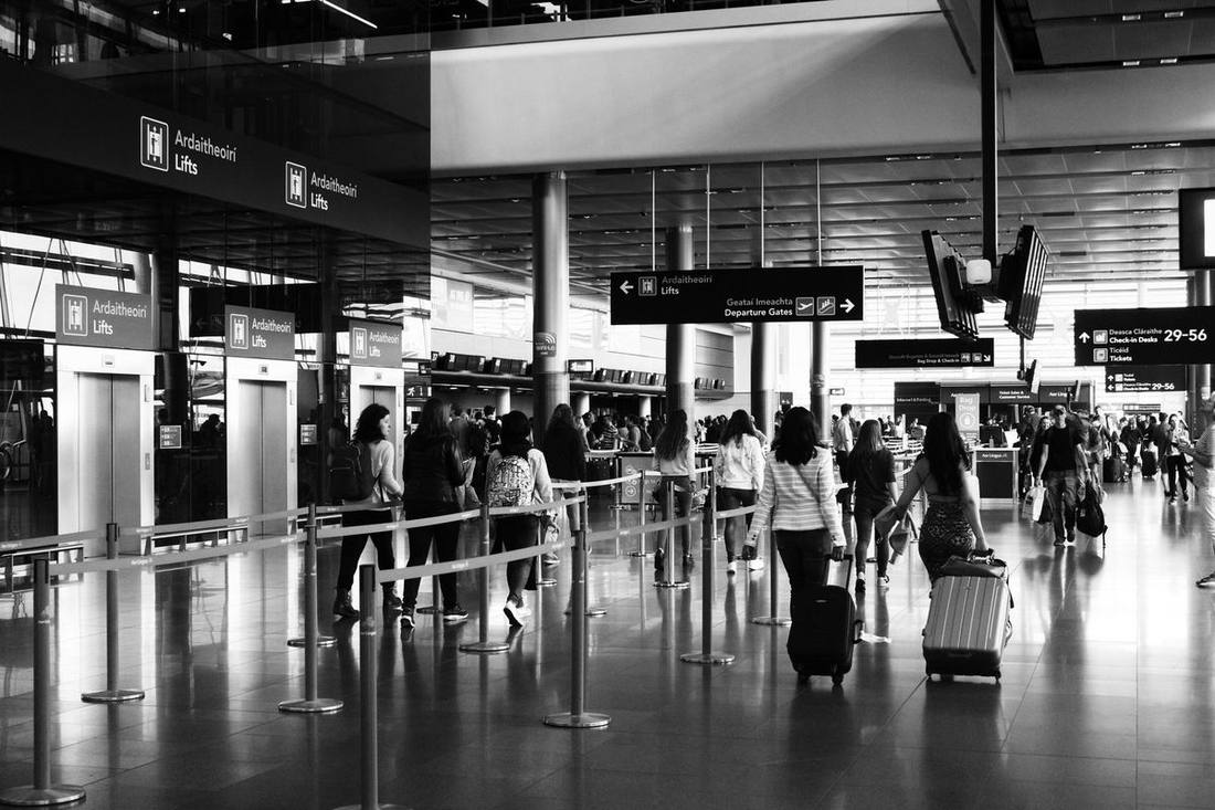 Pearson Terminal 1 departures curb crowded with holiday travellers and luggage while a black SUV pulls in at dawn