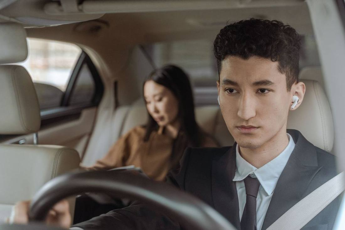 A chauffeur receiving thanks from a passenger at a hotel entrance