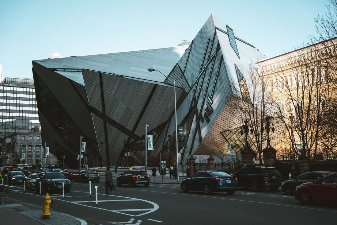 The Royal Ontario Museum's Bloor Street entrance with a black sedan on Queen's Park