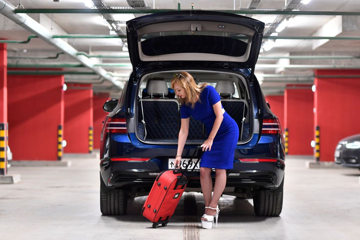 A chauffeur loading luggage into a black SUV