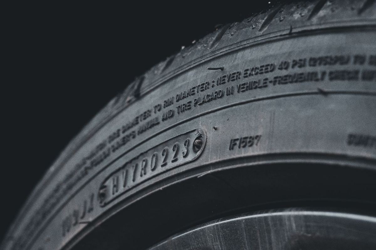 A close-up of a winter tire's sidewall showing the three-peak mountain snowflake symbol beside a tread-depth gauge