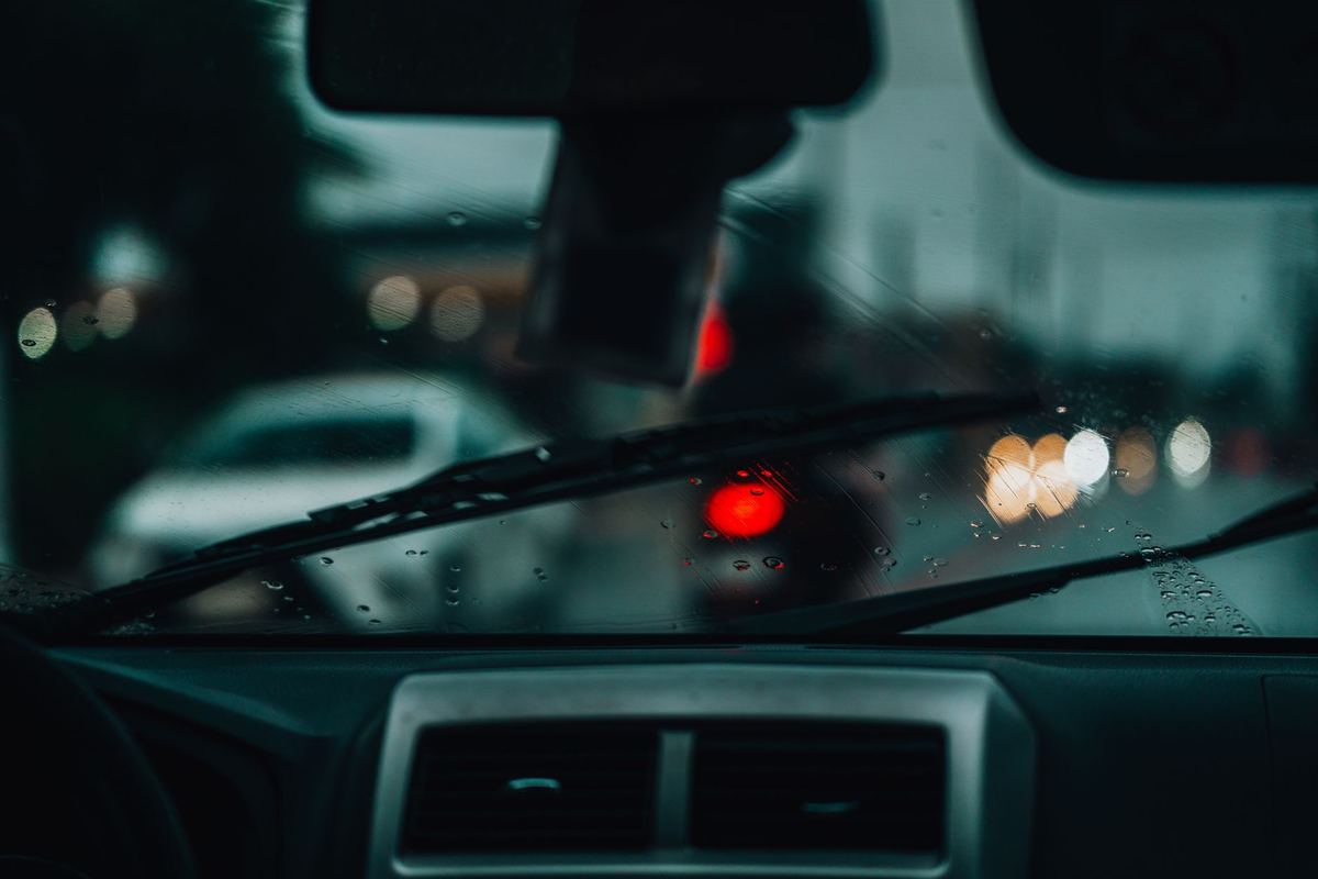 City lights through the windshield on a wet night